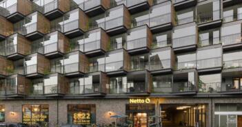 Im dänischen Frederiksberg wurde die Fassade eines Wohnungsbaus aus den 1960er Jahren saniert und in diesem Zuge mit aufgefächerten Kuben erweitert. Die gewonnene Fläche lässt sich von den Bewohnern als erweiterter Wohnraum nutzen.