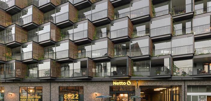 Im dänischen Frederiksberg wurde die Fassade eines Wohnungsbaus aus den 1960er Jahren saniert und in diesem Zuge mit aufgefächerten Kuben erweitert. Die gewonnene Fläche lässt sich von den Bewohnern als erweiterter Wohnraum nutzen.